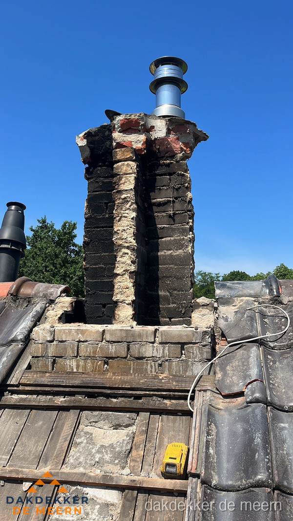 Beschadigde schoorsteen met nieuwe rookgasafvoer op oud dak in De Meern Beschadigde schoorsteen met nieuwe rookgasafvoer op oud dak in De Meern